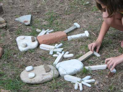 Bambina che gioca con le pietre nell'area giochi del parco sculture di Siena